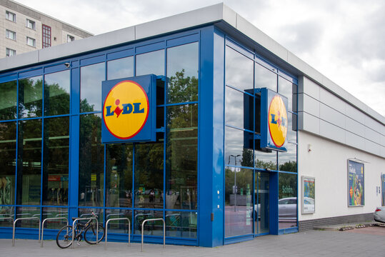 Berlin, Germany - 16 August 2026. A Lidl supermarket sign mounted on a glass storefront outside a retail grocery store. Retail, grocery, discount, brand, shopping, storefront, signage, economy.