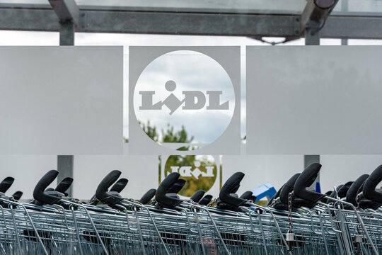 Berlin, Germany - 16 August 2026. Rows of shopping carts are parked at a Lidl trolley bay outside the store. Retail, shopping, consumerism, convenience, commerce, organization, branding.