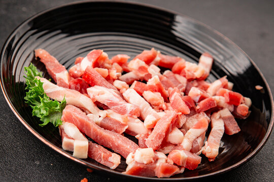 Bacon sliced into pieces pork meat lard serving size natural ingredients healthy eating wholesome dish, tasty snack fresh, gourmet, rustic food background on the table top view copy space