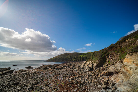 Rocky shoreline and bay viewed from Samphire Beach, Looe, Cornwall, UK