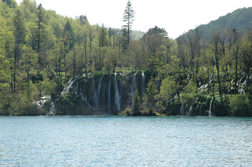 Scenic view of small waterfalls and cascades flowing directly into Kozjak Lake seen from a boat in Plitvice Lakes National Park Croatia. © nahhan