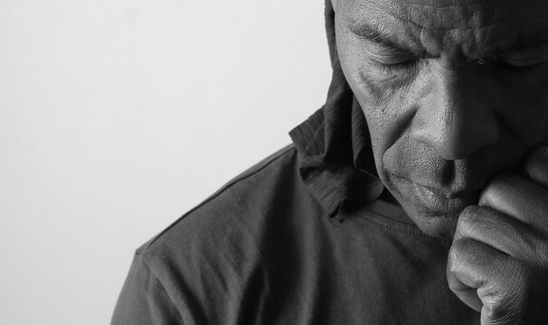 praying to god with hands showing his religious faith with God Caribbean man praying with background with people stock photo stock image
