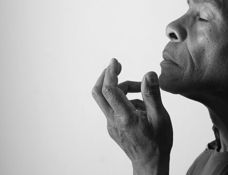 praying to god with hands showing his religious faith with God Caribbean man praying with background with people stock photo stock image
