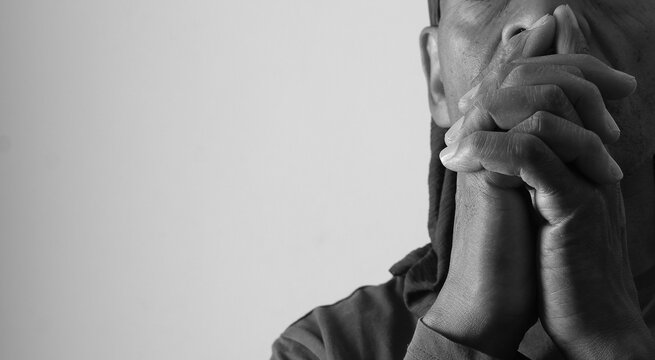 praying to god with hands showing his religious faith with God Caribbean man praying with background with people stock photo stock image