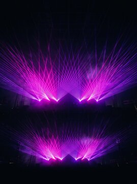 Magenta and violet symmetrical laser wings on black background, wide stage lighting fan overlay, electronic concert visual effect