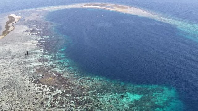 Surrounded by clear, warm seas, a remote platform coral reef thrives near Halmahera, Indonesia. This region is home to extraordinary marine biodiversity and is a destination for divers and snorkelers.