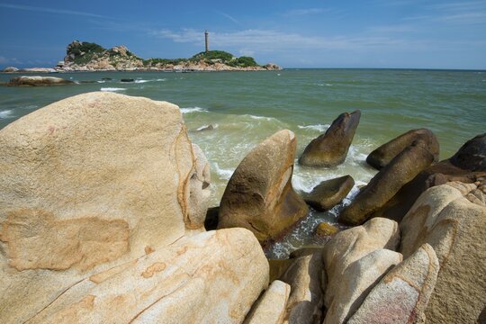 Sandstones in the surf, in the back highest Lighthouse of Vietnam, Phan Thiet, Ke Ga, Vietnam