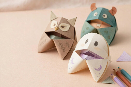 Origami paper fortune teller puppets as Halloween ghost owl and monster with colored pencils