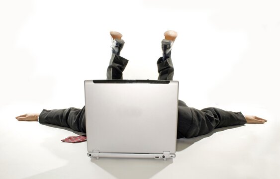 Business man lying with spread out arms behind a notebook