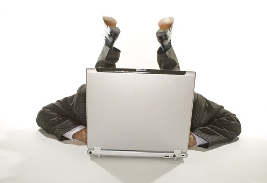 Business man lying behind a notebook