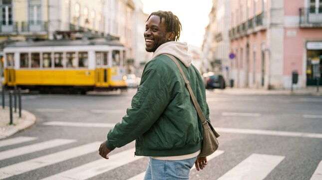 Carefree man crossing city street with vintage yellow tram looking over shoulder
