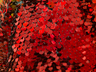 Red sequins close up, shimmering round discs layered like fish scales with highlights, festive Christmas and New Year background. Holiday glitter concept, grainy film texture, high quality photo © Татьяна Швец