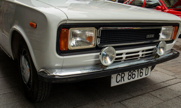 GANDIA, SPAIN - OCTOBER 4, 2026 Front view of a vintage white SEAT 124 classic car on display at an outdoor automobile exhibition.