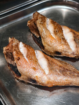 Grilled grouper displayed at a supermarket seafood counter, showcasing prepared fish as a ready to buy product for customers in the fish department
