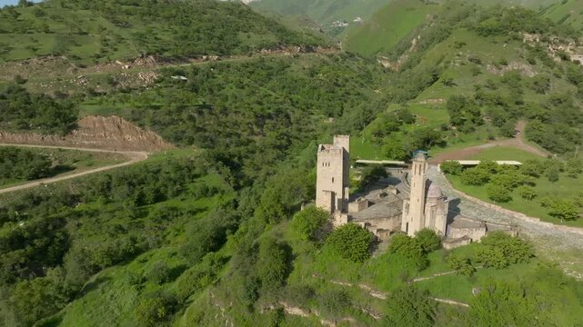 High angle aerial view of the stone towers at Vatan memorial complex in Sogratl Dagestan Russia surrounded by picturesque green mountain slopes and scenic natural valleys on sunny day