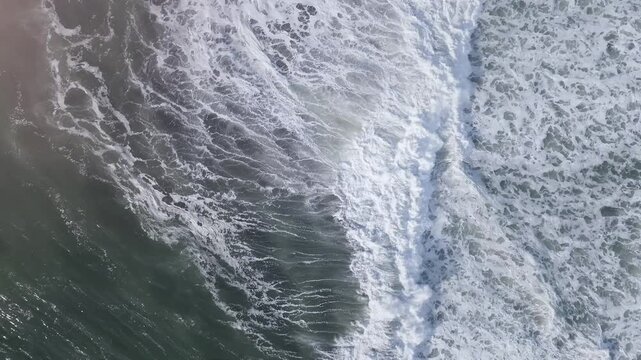 Drone footage captures dramatic sea surf crashing along the scenic coastline of Kamchatka Krai in Russia, showcasing white foam and dynamic tidal motion in stunning natural detail