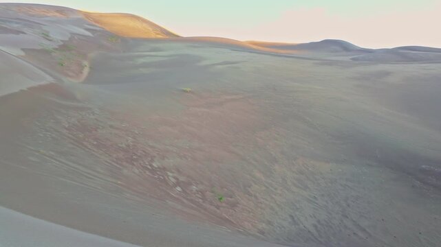 Golden morning sunlight crests towering ridges of sand in Great Sand Dunes National Park