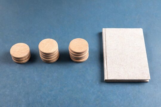 Wooden disc stacks beside a closed linen notebook