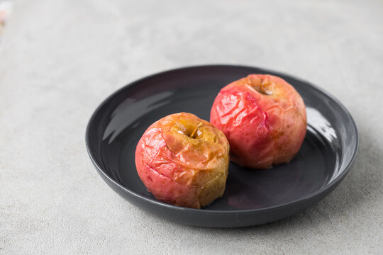 Vegan food. Baked sweet aples. On a plate. Light background. Close up. Copy space