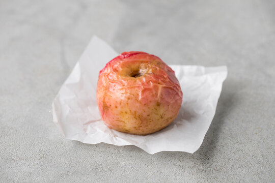 Baked sweet aple. On white paper. Light gray background. Close up