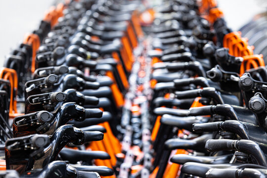 Rows of rental bikes and sharing bicycles parked in the city downtown ready for city commute. Ride sharing.