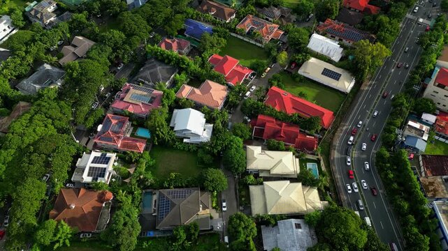 Aerial view of New Alabang Village, a residential community in Alabang, Muntinlupa, Philippines, with tree-lined streets, houses, tropical vegetation and surrounding urban development visible from abo