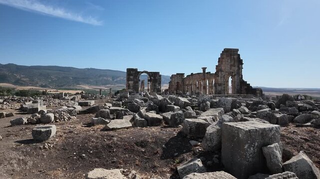 panorama overlooking extensive archaeological foundations, stone walls, and distant valley landscapes at Volubilis, Morocco