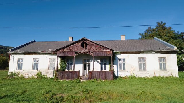 Traditional countryside house with a red tiled roof and surrounding rural landscape in Cacica, Suceava, Romania.