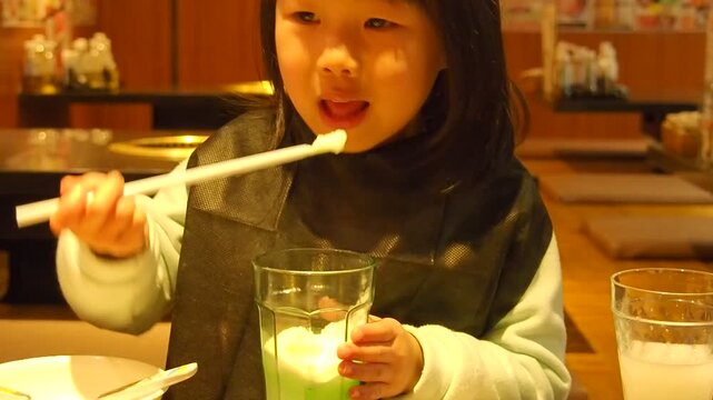 焼肉店内で楽しく食事する幼児の女の子の姿