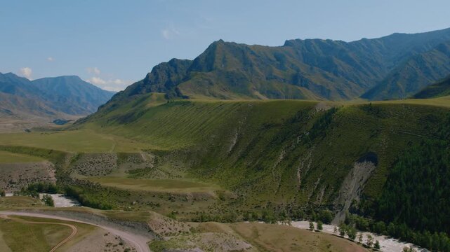 Panoramic drone footage of the confluence of Chuya and Katun rivers flowing through a majestic scenic green valley among high mountain peaks in the Altai Republic region of Russia