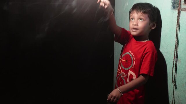 Young child holding a sparkling firework during diwali celebrations