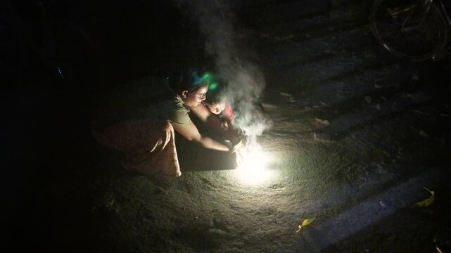 Mother and child celebrating diwali with sparklers at night
