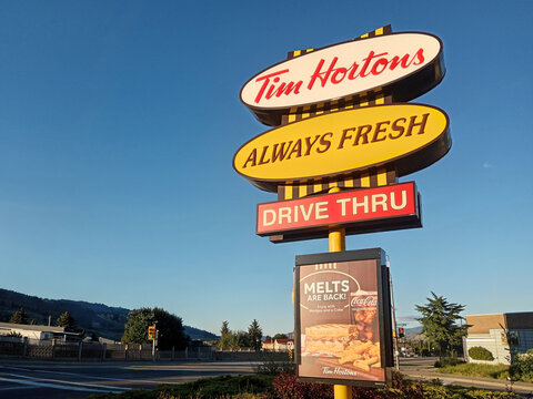 Penticton, Canada - June 21, 2026: Sign for Tim Hortons is displayed with menu board at a drive thru location in Penticton, British Columbia, Canada. It shows offers like melts and drinks.