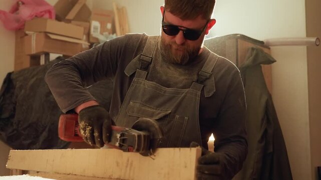 Carpenter operates angle grinder on wooden material within workshop setting. scene shows man actively cutting through lumber with sparks visible from friction between tool and workpiece