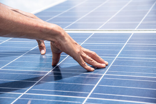 Close up of technician hands inspecting solar panel surface
