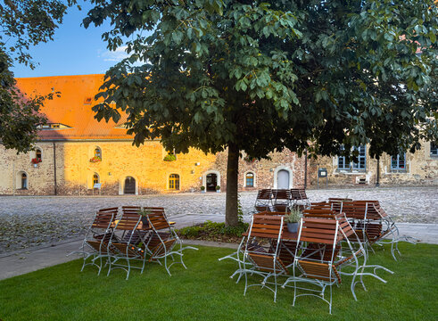 Saisonende, Gem&uuml;tlicher Biergarten im historischen Innenhof der Burg Eisenhardt am Abend, Bad Belzig, Brandenburg, Deutschland