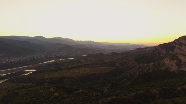 Winding Mtkvari River Through Georgia&rsquo;s Mountain Valley at Golden Hour, Aerial View of the Caucasus Landscape at Sunset