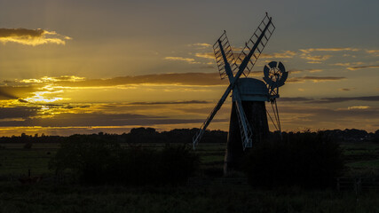 Mutton’s mill windmill silhouetted against golden sunset sky in norfolk © jmh-photography