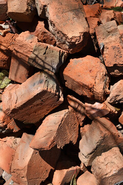 old brick. red brick. a haphazardly thrown pile of old broken bricks. a concept of a ruin, a war or natural disaster, construction, renovation. building materials, dismantling. for background. closeup