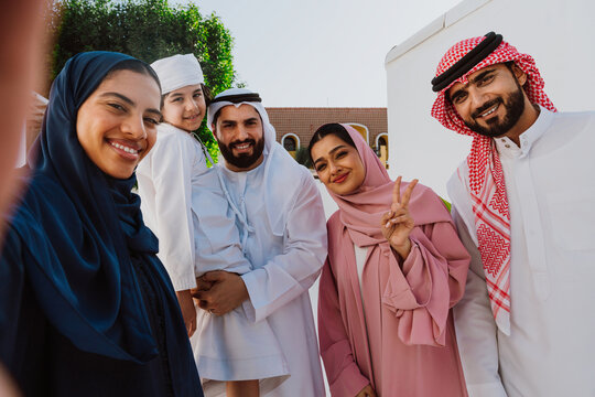 Emirati family standing together smiling in traditional attire