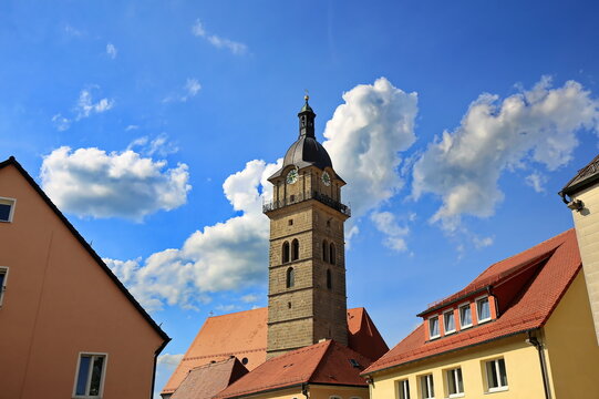 Blick auf die katholische Stadtpfarrkirche St. Johannes der T&auml;ufer in Auerbach in der Oberpfalz mit ihrem markanten barocken Kirchturm unter strahlend blauem Sommerhimmel.