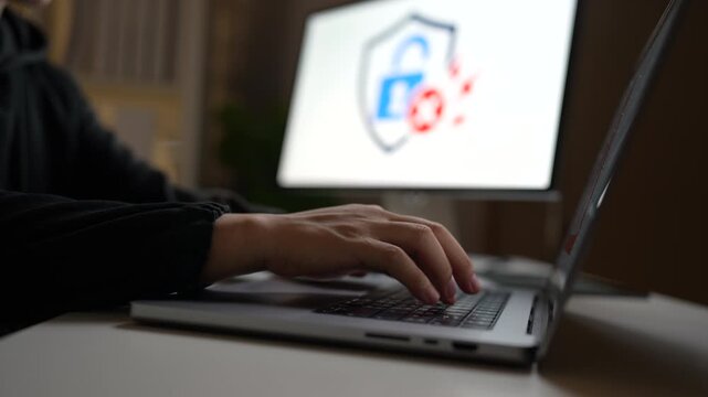 Cybersecurity threat displayed on laptop and computer screens with red warning symbols and a hacked alert, representing a cyberattack and data breach.