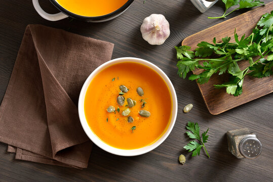 Creamy pumpkin soup garnished with seeds and thyme