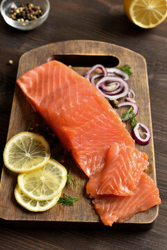 Fresh salted salmon with spices on cutting board