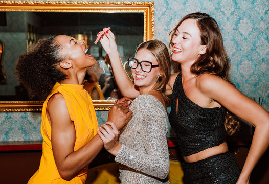 Three diverse friends enjoying a party night celebration