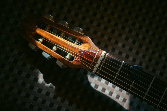 Head and neck from an acoustic guitar under sunlight
