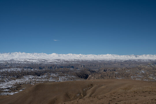 A deep ravine leading toward snowy mountains in Zanda