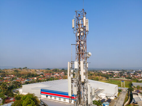 Aerial View of a Telecommunication Tower with Radio Masts and Equipment Near a Retail Warehouse in the Morning in Purwokerto, Central Java, Indonesia.