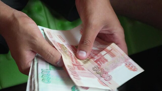 Hands counting Russian ruble banknotes, money calculation, financial transaction