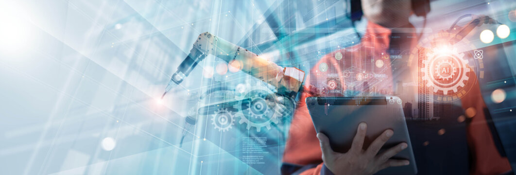 Industrial engineers use a tablet to analyzing data production and monitor digital dashboards in smart factory with robotic automation system optimizing smart of manufacturing processes.